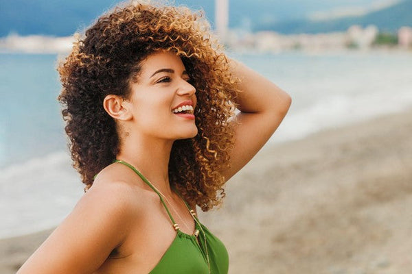 Woman with curly hair on the beach