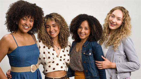 Four women with curly hair