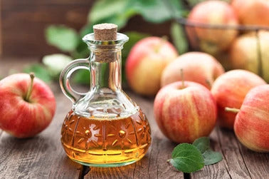 Bottle of apple cider vinegar and apples