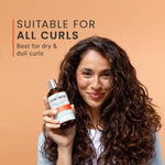 Woman holding a bottle of hair care product with text about suitability for all curls on an orange background